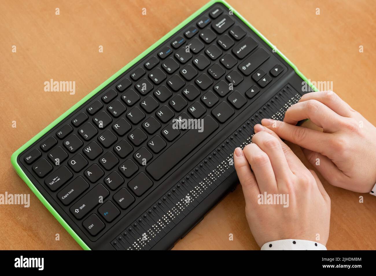 A blind woman uses a computer with a Braille display and a computer