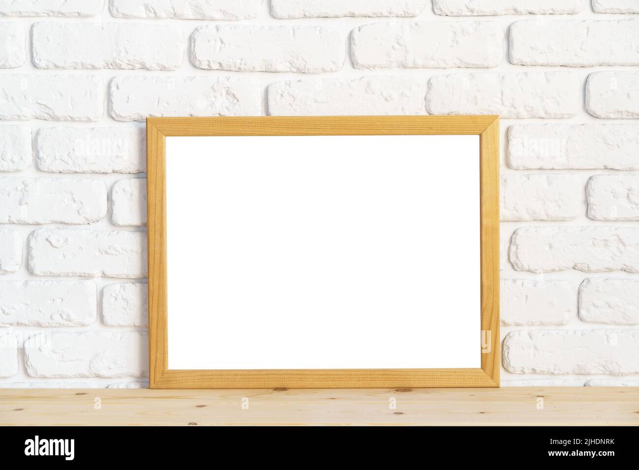 Photo frames on floor over white brick wall Stock Photo
