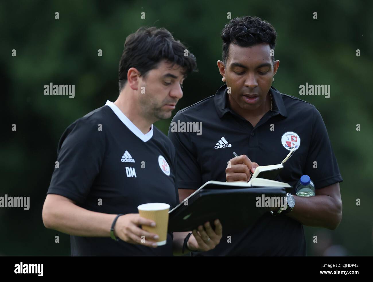 Crawley Town manager Kevin Betsy (R) talks with  assistant coach Dan Micciche seen during the Pre-Season Friendly between Three Bridges FC and Crawley Town FC at the Jubilee Field in Three Bridges 13th July 2022 Stock Photo