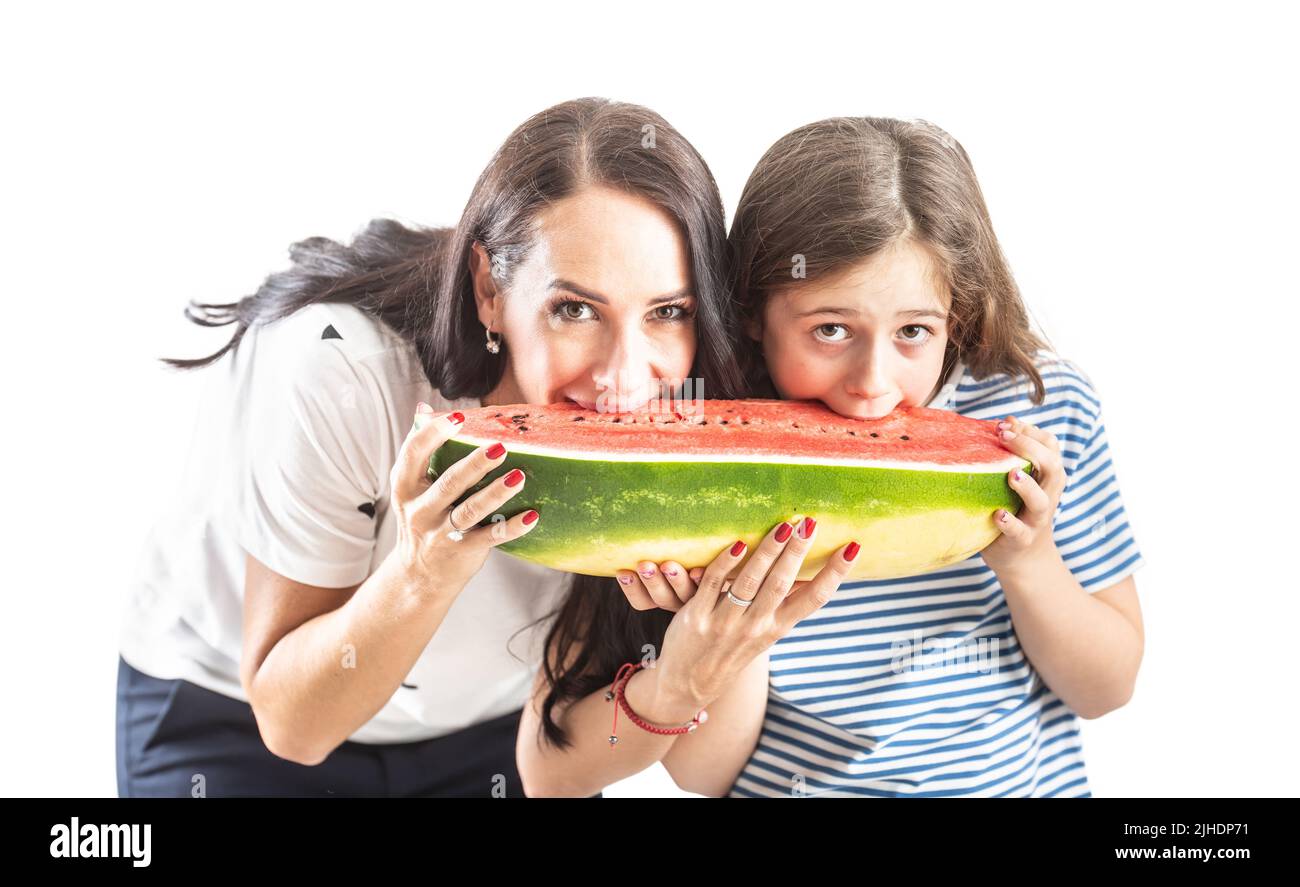 Mom and daughter are eating a huge watermelon - Isolated on wtite. Stock Photo