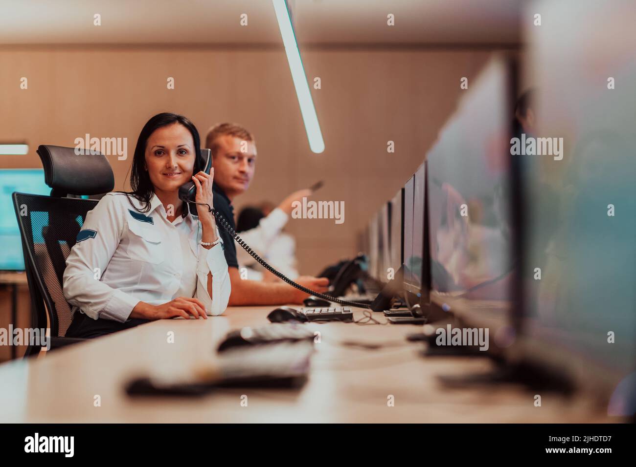 Female security guard operator talking on the phone while working at ...