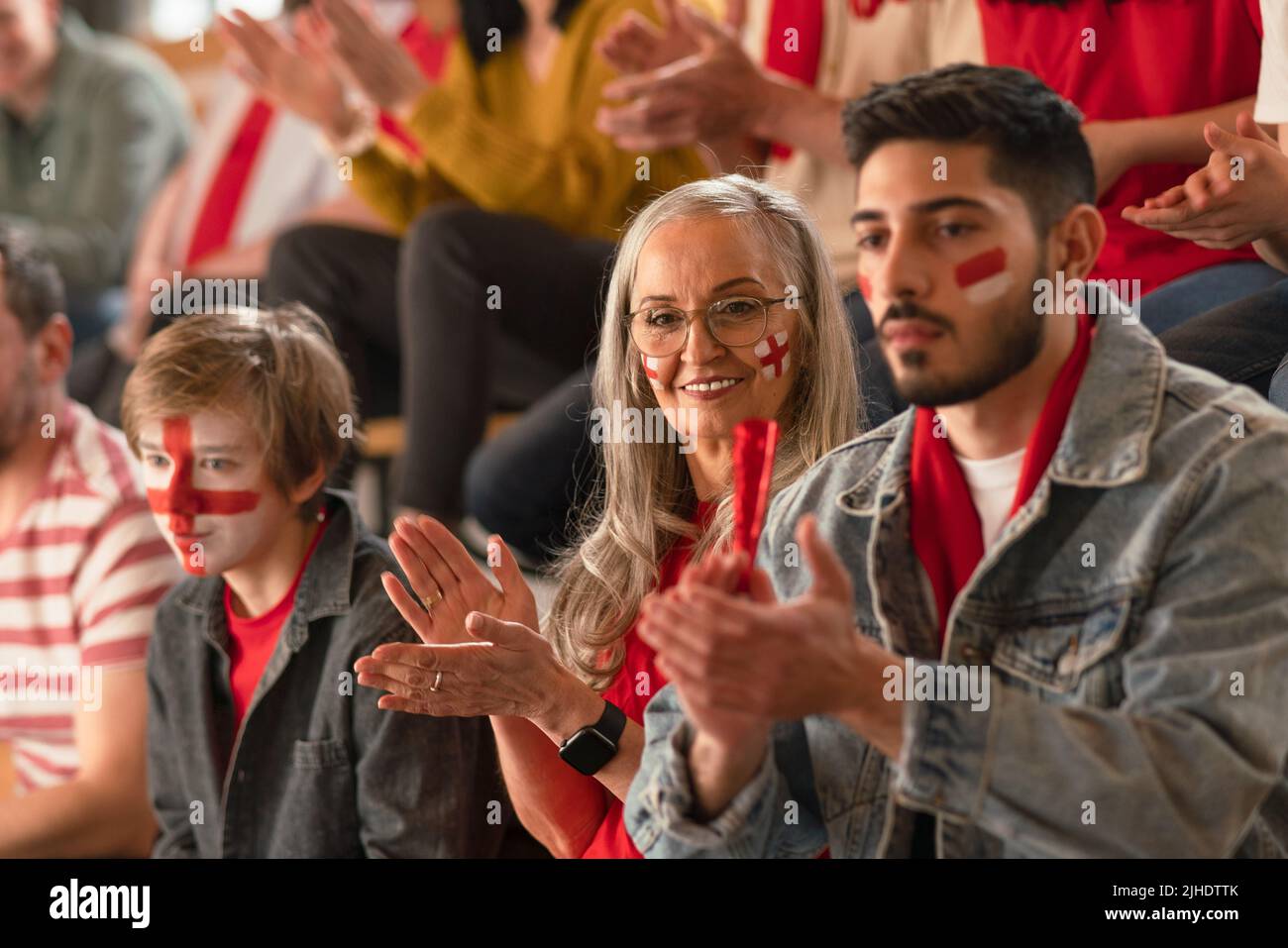 Excited football fans supporting English national team in live soccer match at stadium Stock