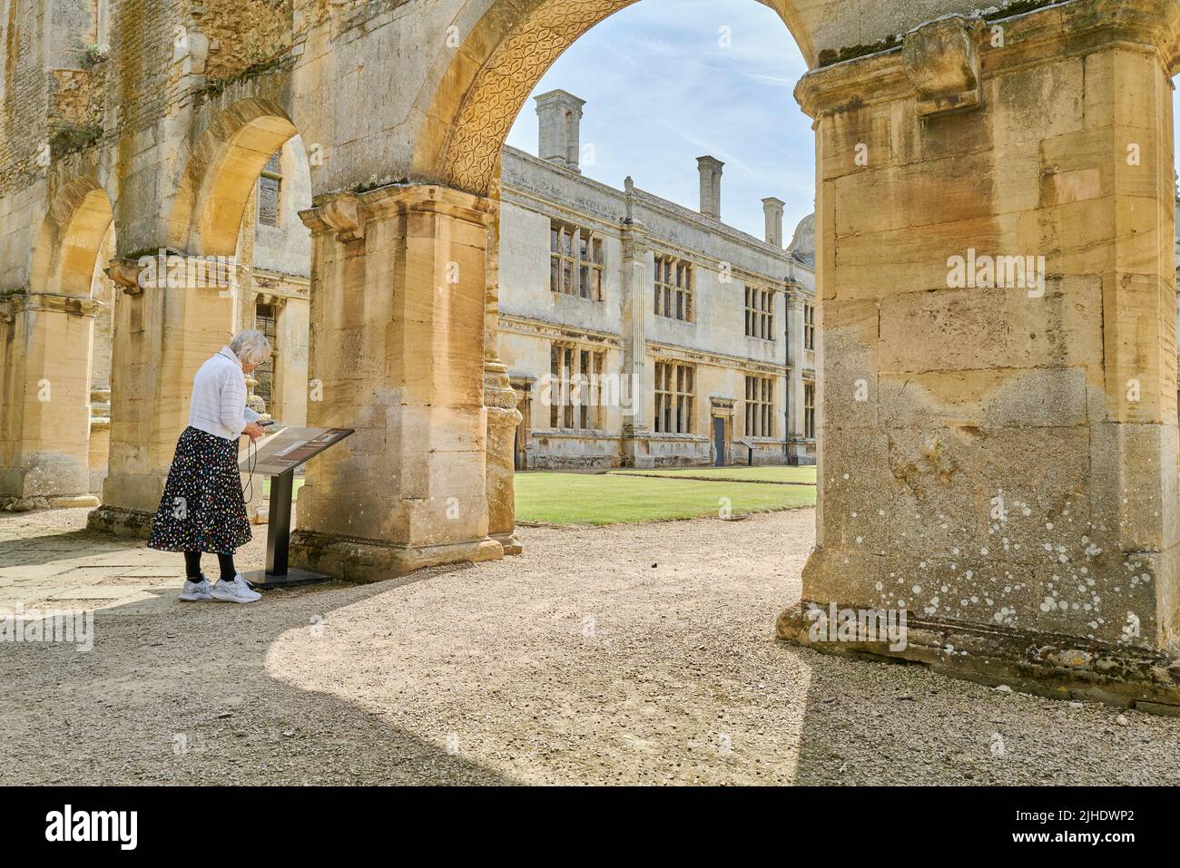 Elderly woman next the well kept garden in the inner court of a ...