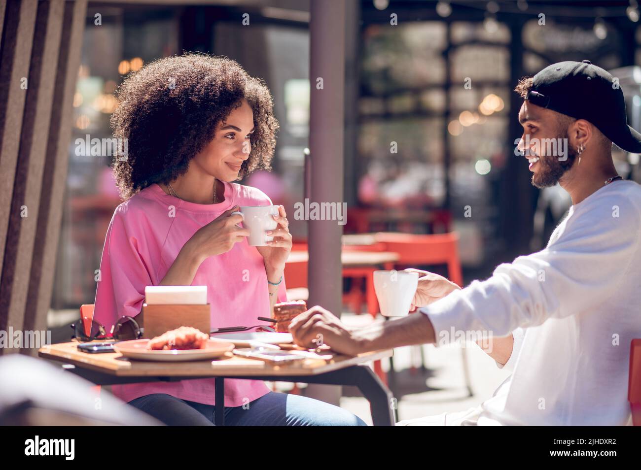 Cute young couple having coffee in the cafe Stock Photo - Alamy