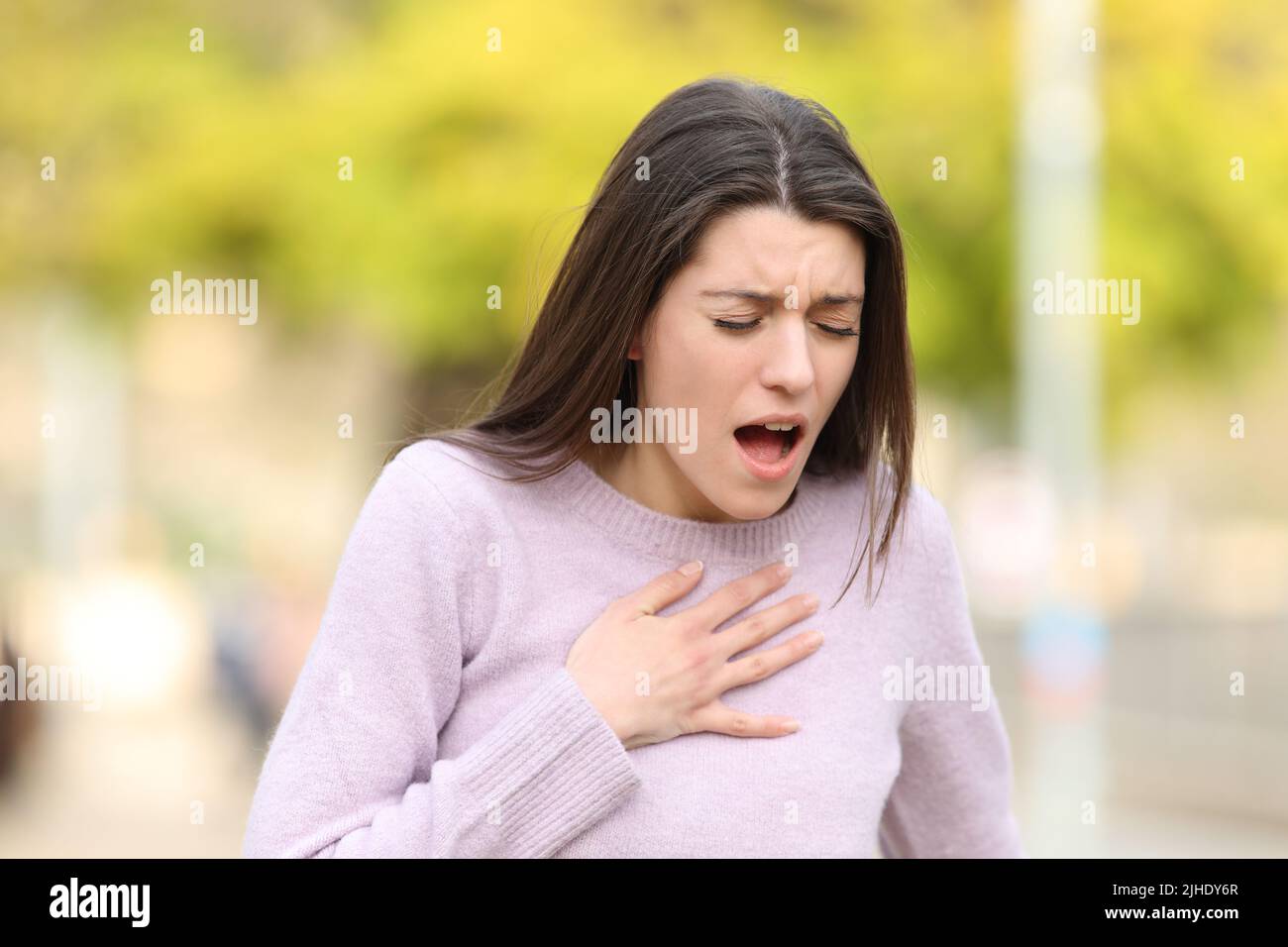 Stressed teen having breath problems standing in a park Stock Photo