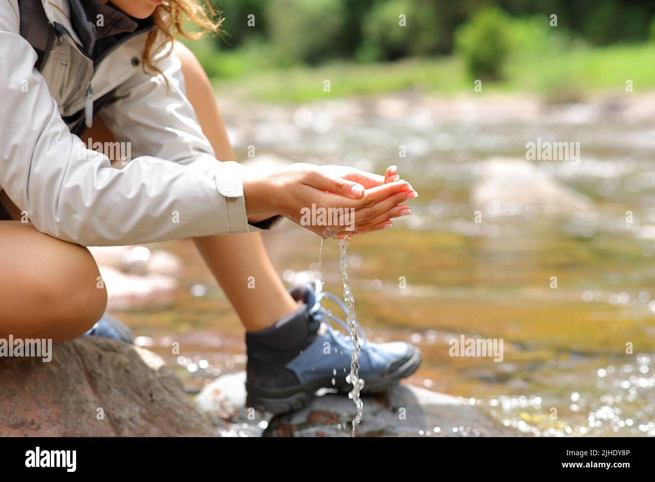 Close up of a trekker with cupped hands catching water from river in the mountain Stock Photo