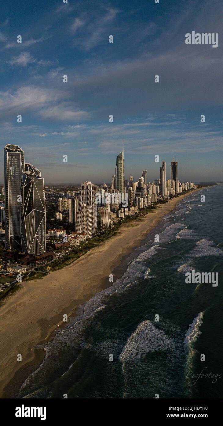 Drone view of tall buildings of coastal city ,sandy beach and waves of ...