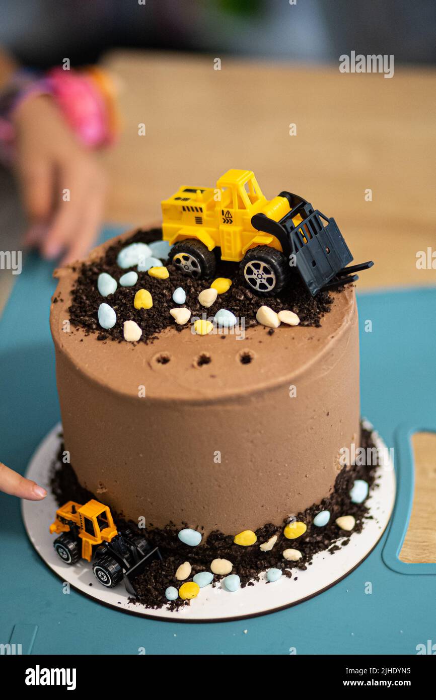 Chocolate brown cake with yellow toy decoration tractors party birthday
