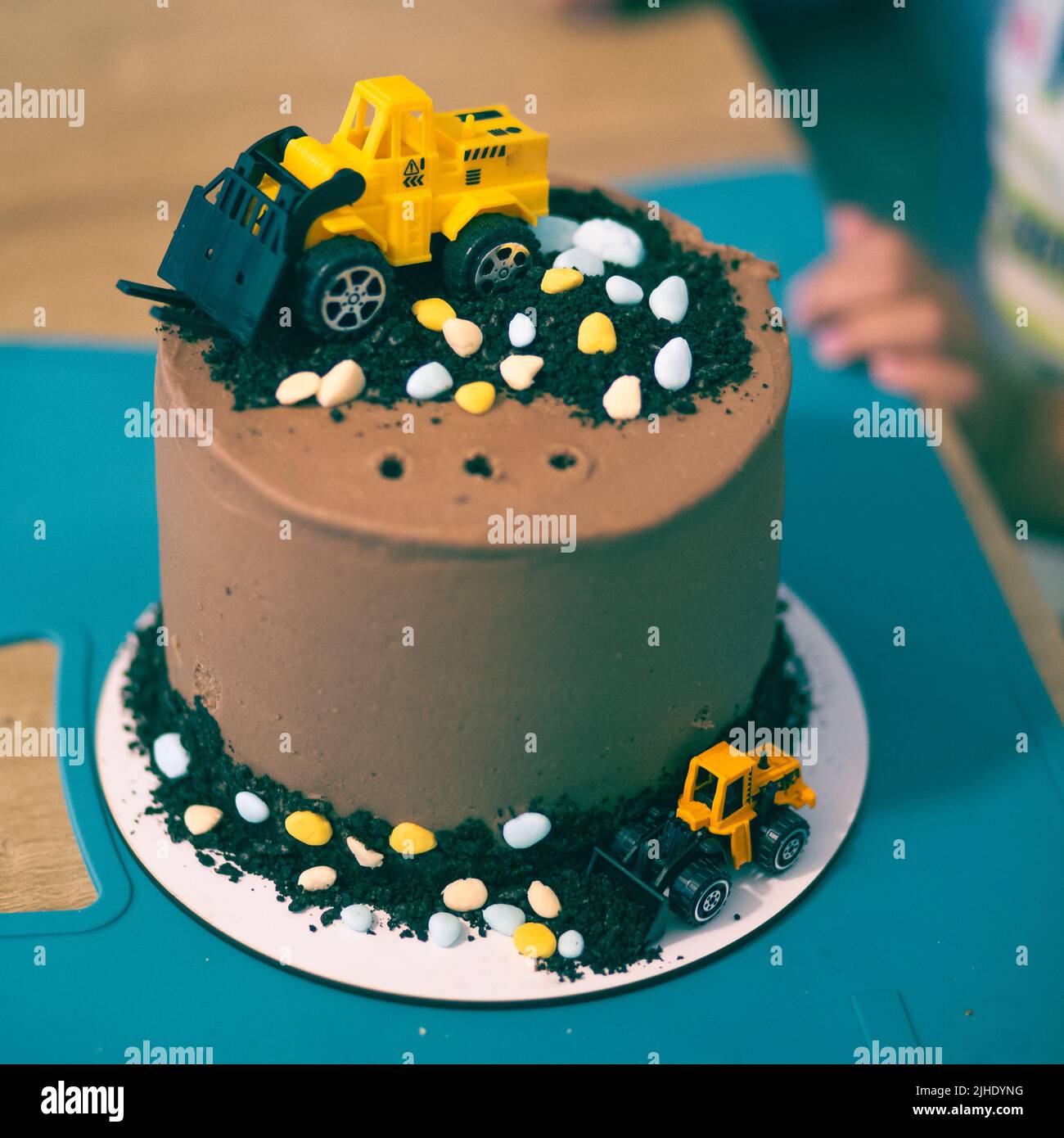 Chocolate brown cake with yellow toy decoration tractors party birthday