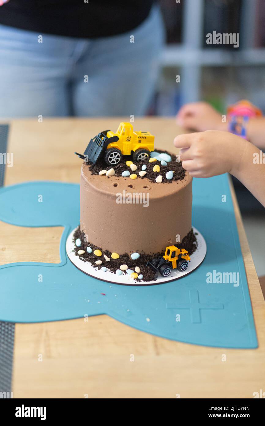 Chocolate brown cake with yellow toy decoration tractors party birthday