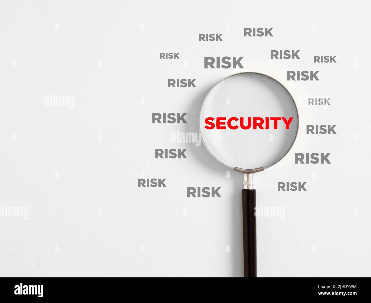 Business risks and security concept. Secure business environment and security assessment. Magnifying glass magnifies the word security surrounded with Stock Photo