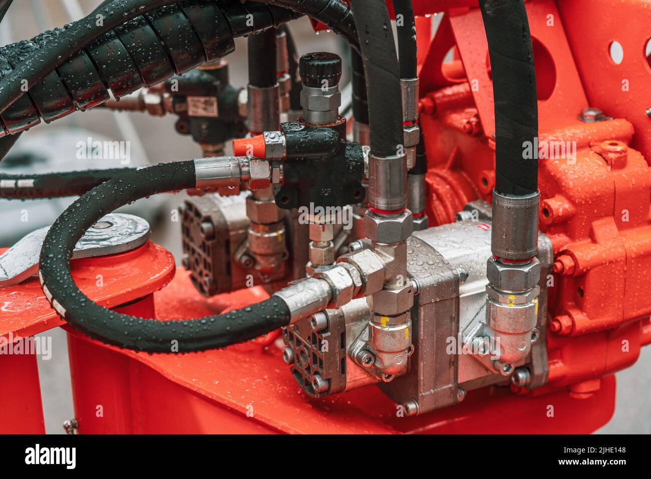 Hydraulic power unit mechanical valve with pipes and connections on heavy industry machine close-up. Stock Photo