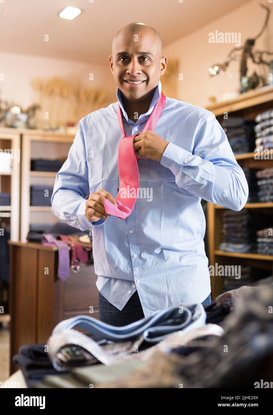 Man choosing new tie in clothing boutique Stock Photo - Alamy
