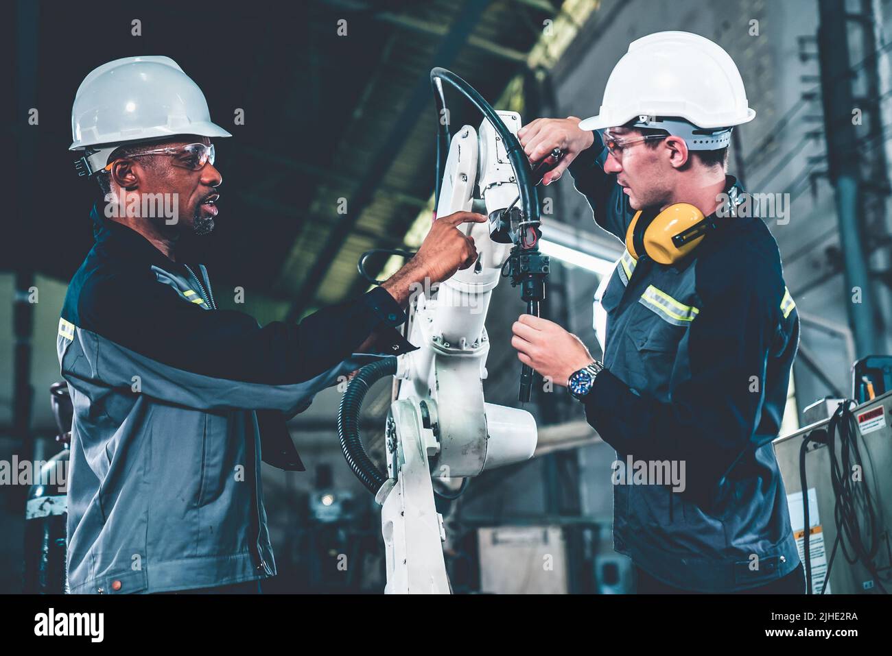 Factory workers working with adept robotic arm in a . Industry