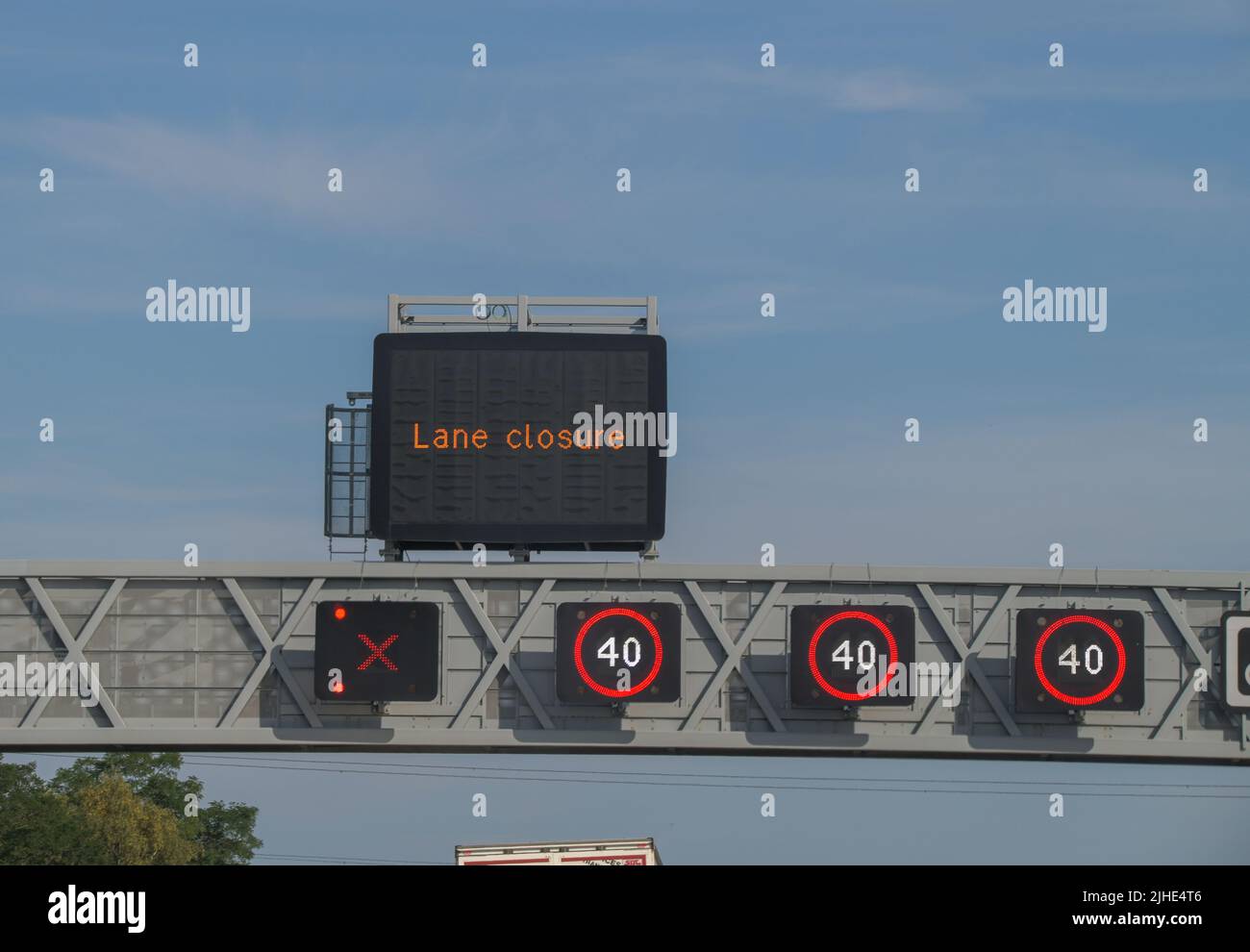 A smart motorway signs stating the national speed limit is restricted to 40 miles per hour and a lane is closed, lane prohibited Stock Photo
