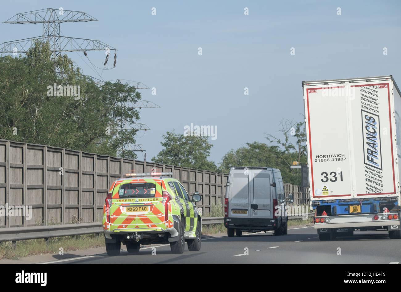 Highways Traffic Officer helping a stranded van in a lane of a smart motorway with a deteriorated tyre. Stock Photo