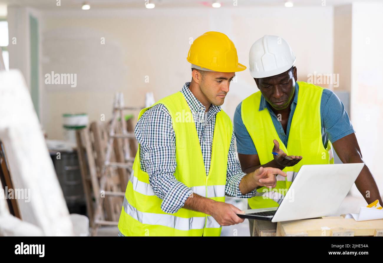 Male engineers using laptop in building site Stock Photo