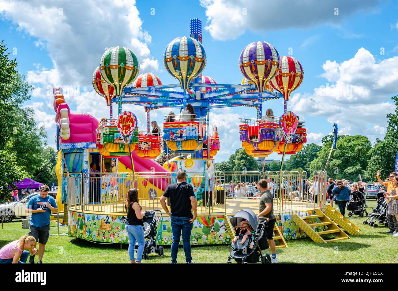 A children's fairground ride with carriages with balloons which spin and rise and fall. Stock Photo