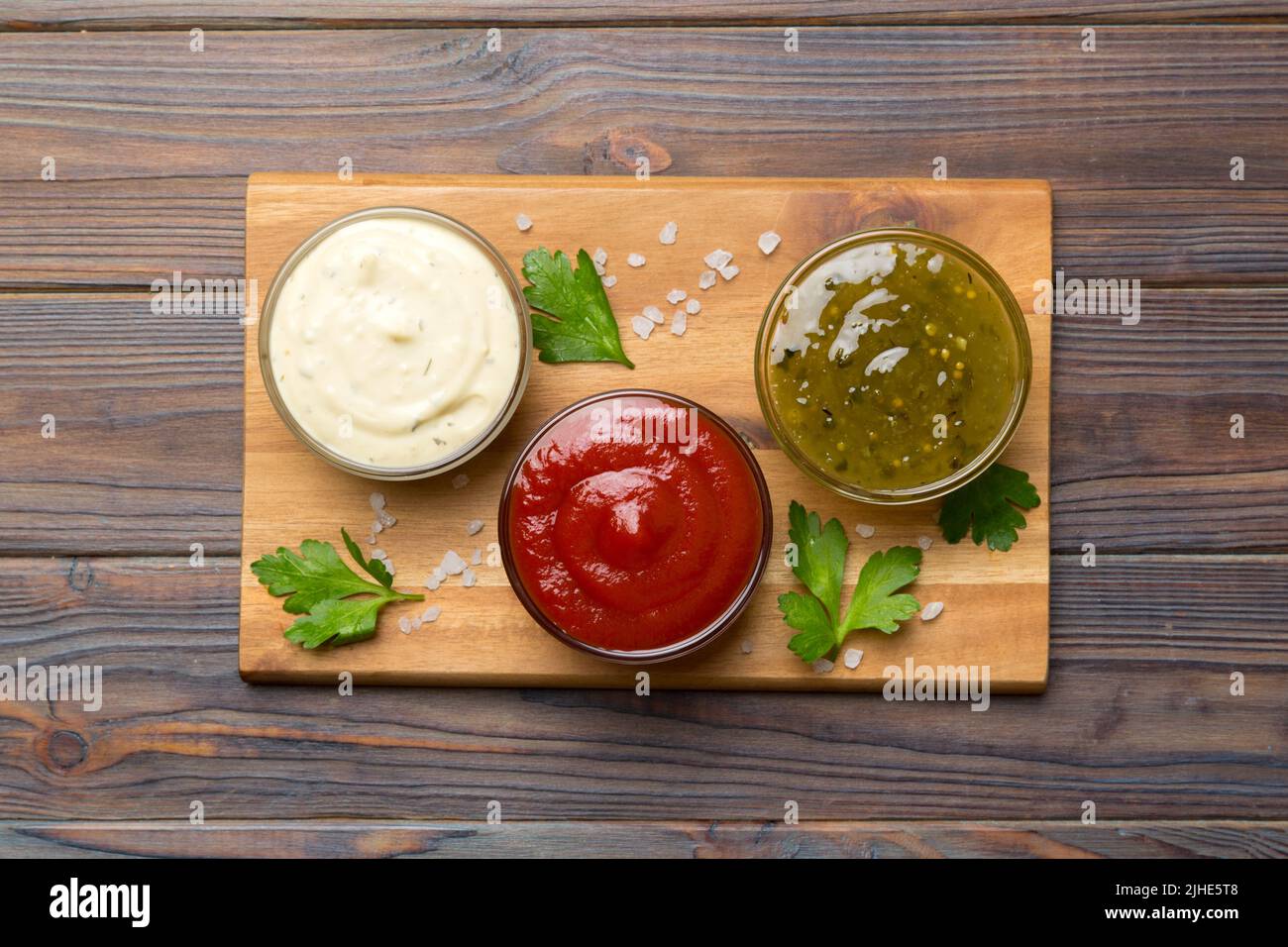 Many different sauces and herbs on table, flat lay top view. sauces on ...