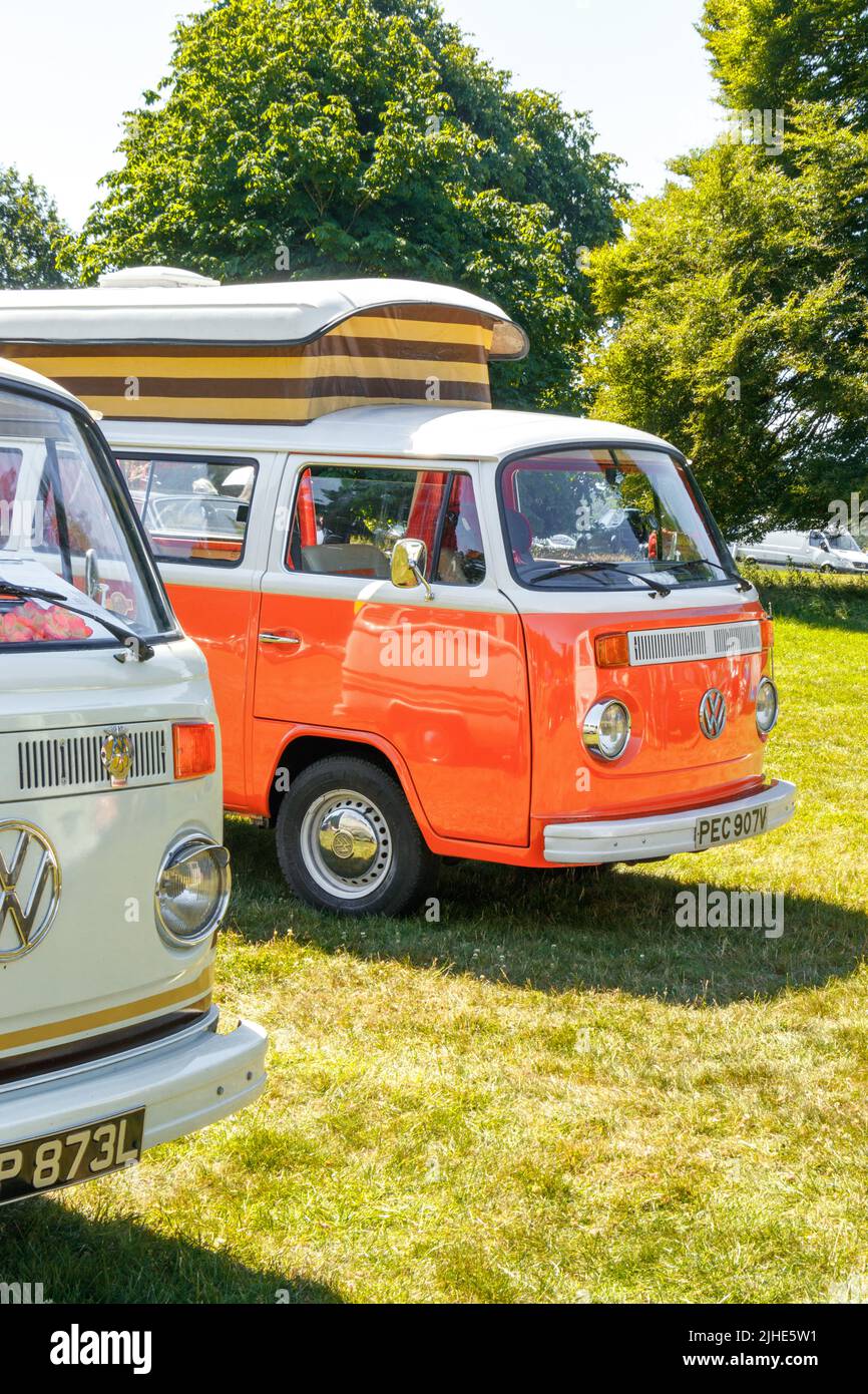 two vintage volkswagen VW campervans one orange with pop top roof the ...