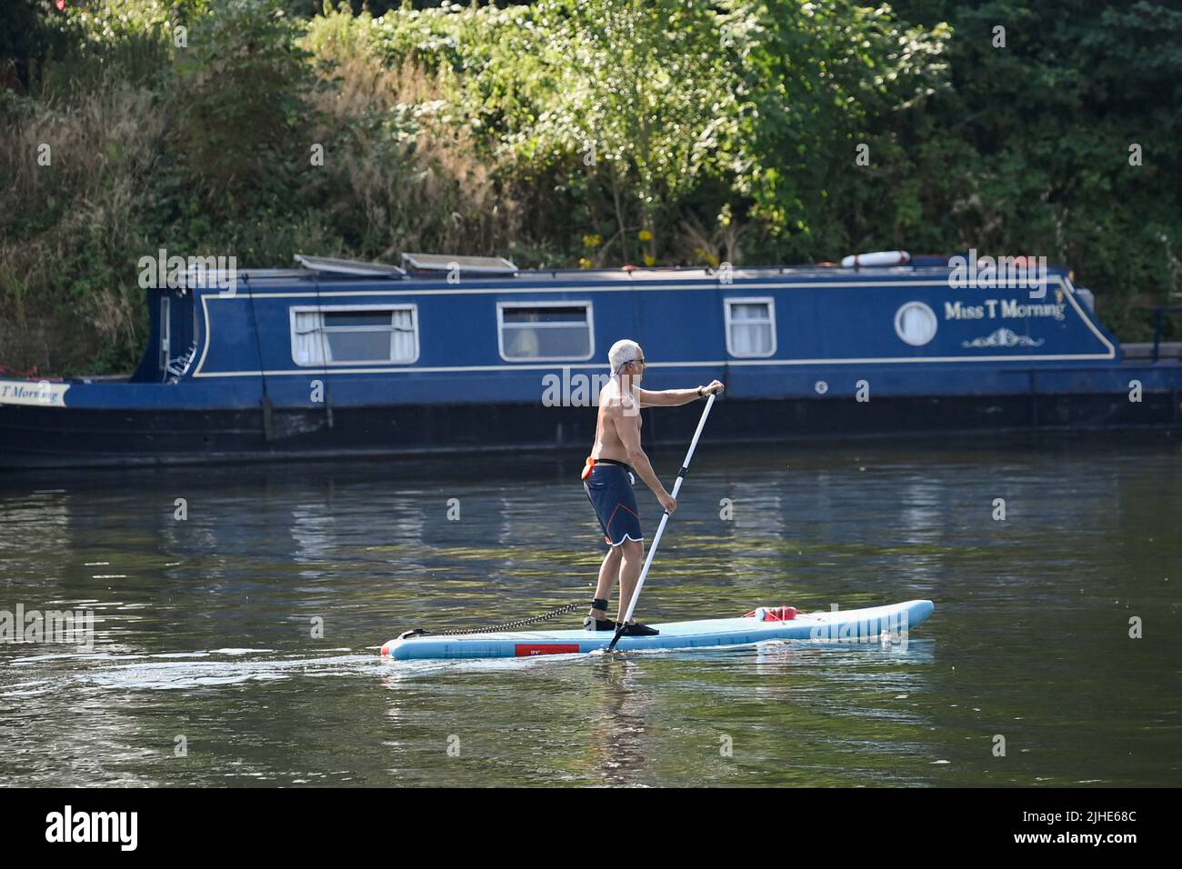 A man uses a stand-up paddleboard on the River Thames during the hot weather at Shepperton near Windsor, Britain, July 18, 2022. REUTERS/Toby Melville Stock Photo