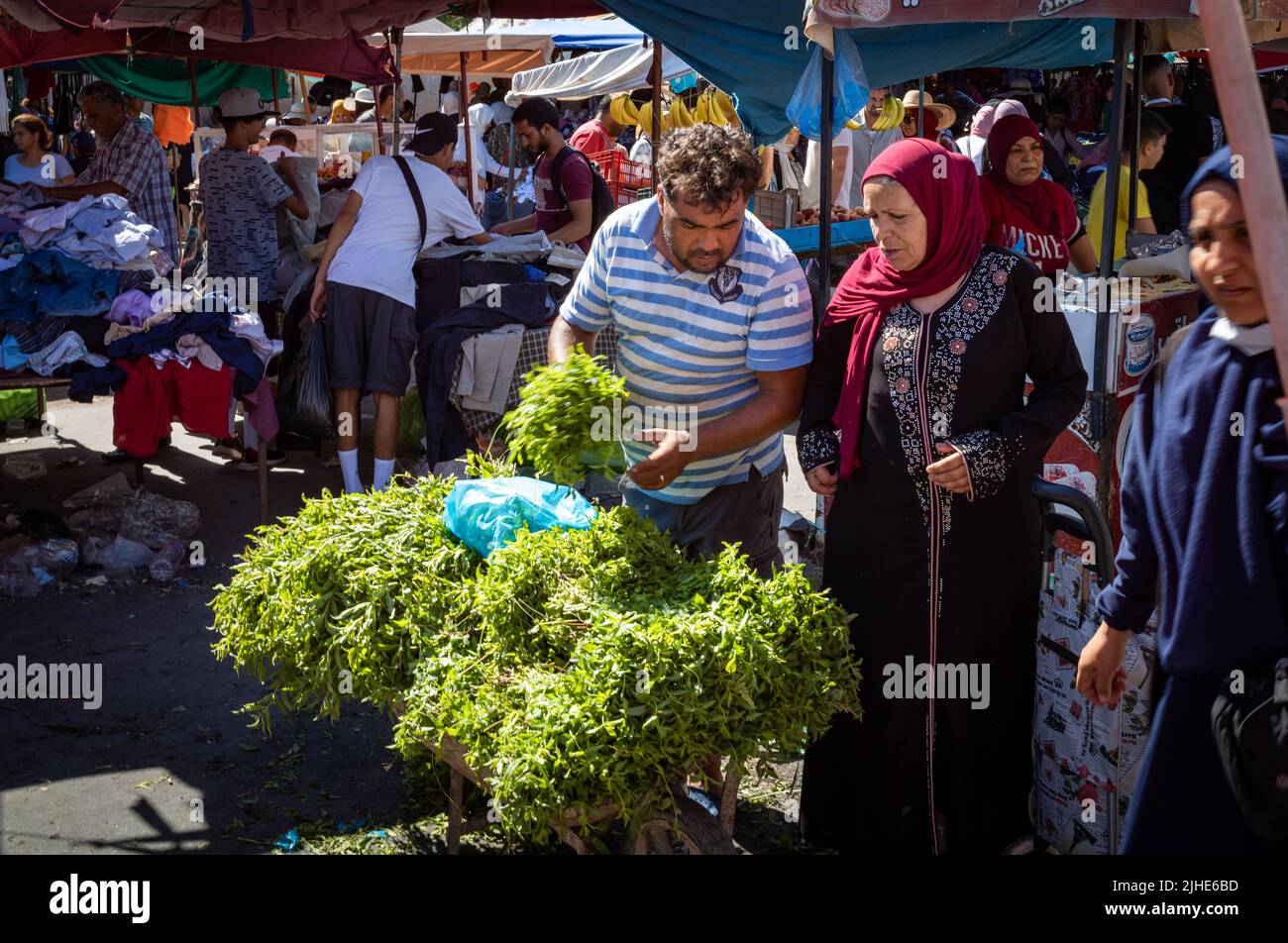A woman buys fresh mint in the Sunday Souk, a weekly market in Sousse, Tunisia. Stock Photo