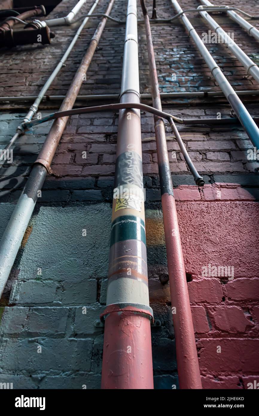 Drain pipes on brick wall, Wellington, North Island, New Zealand Stock Photo