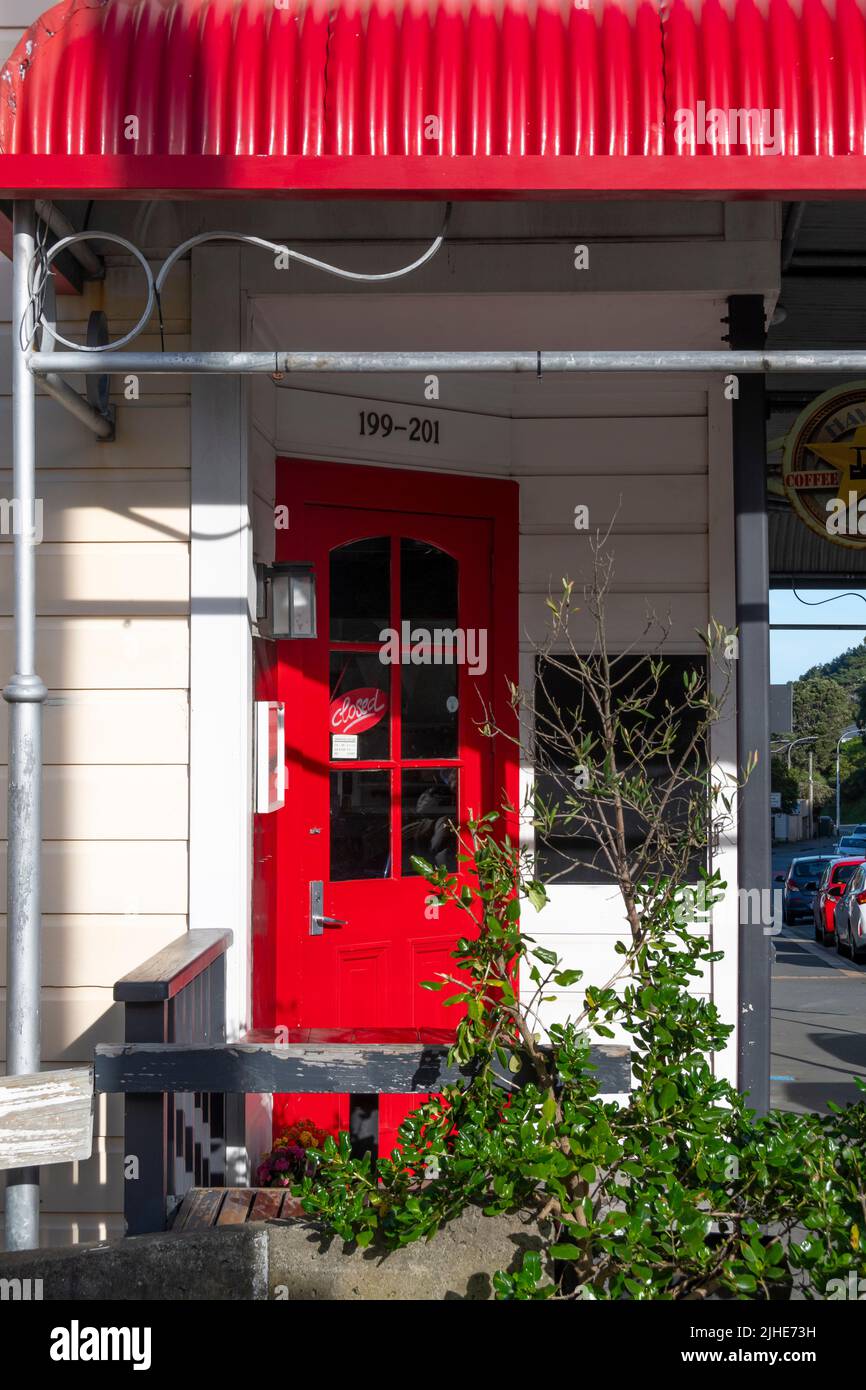 Red door in white house, Brooklyn, Wellington, North Island, New Zealand Stock Photo