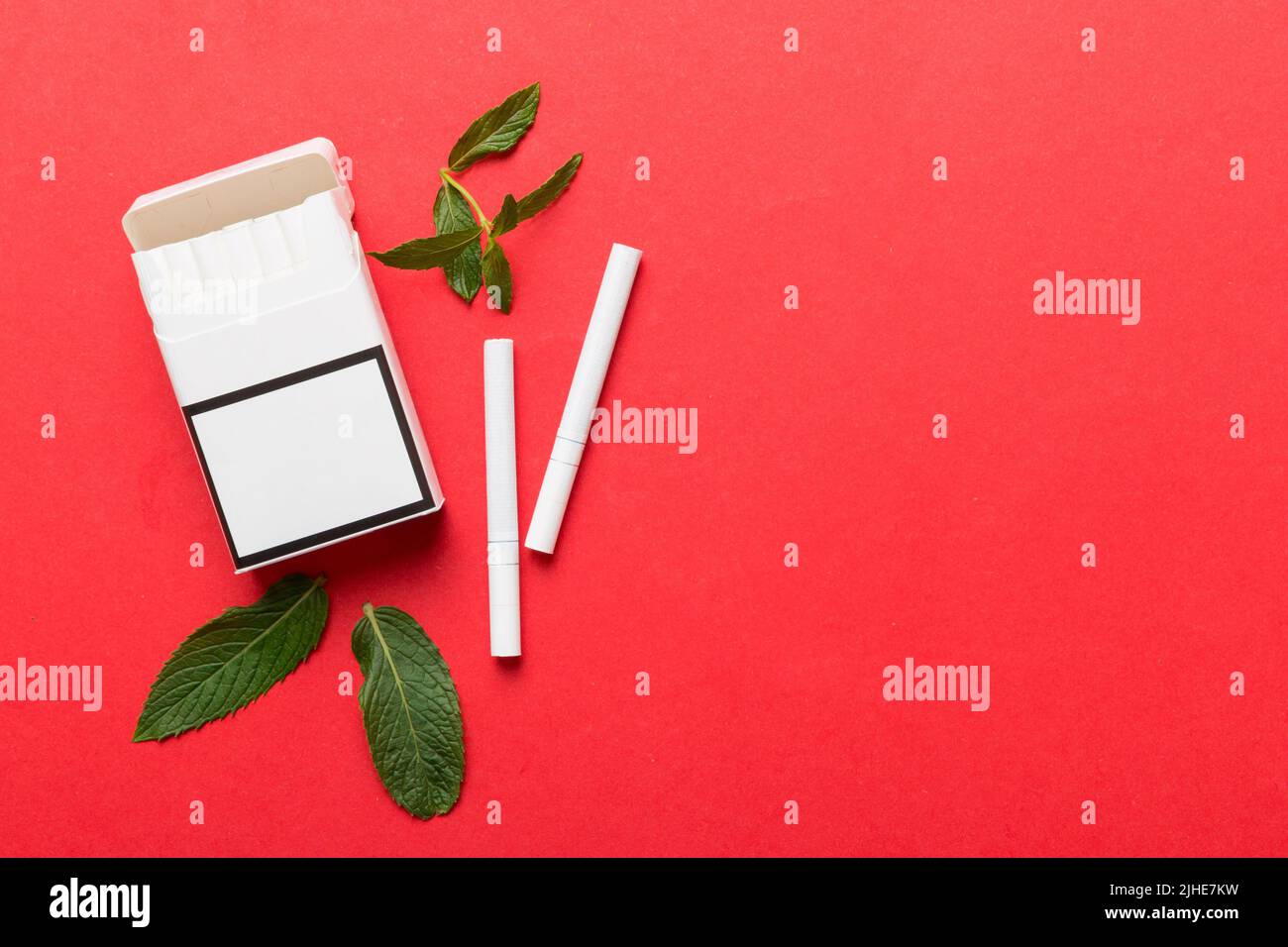 Pack of menthol cigarettes and fresh mint on colored table, Menthol