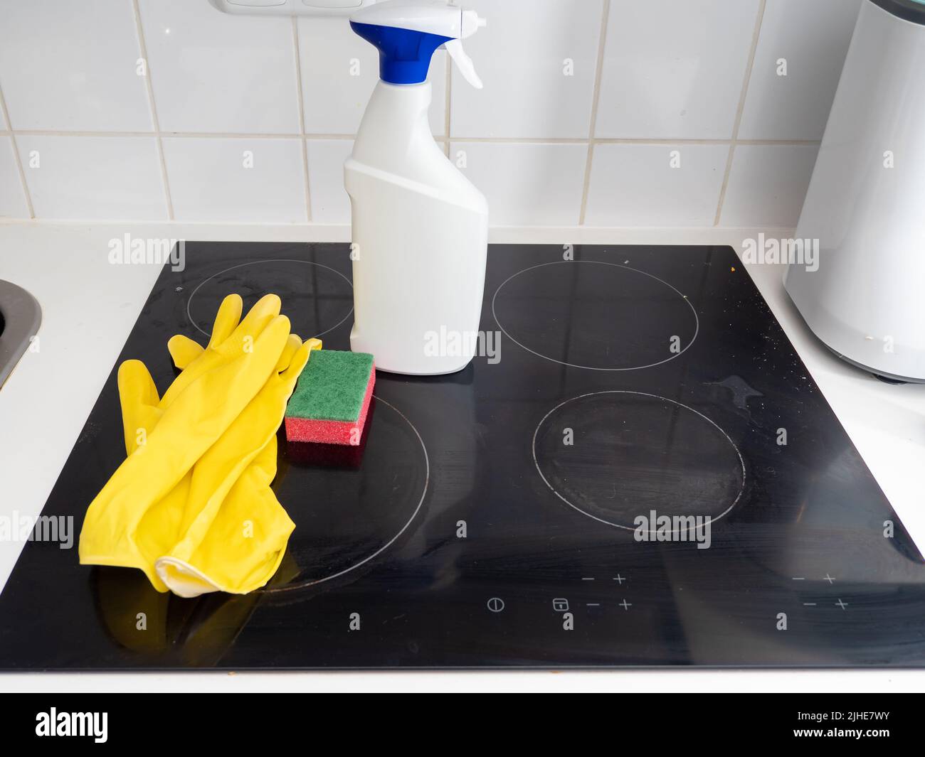 Washes the electric stove. Kitchen cleaning. Dirty electric stove Stock