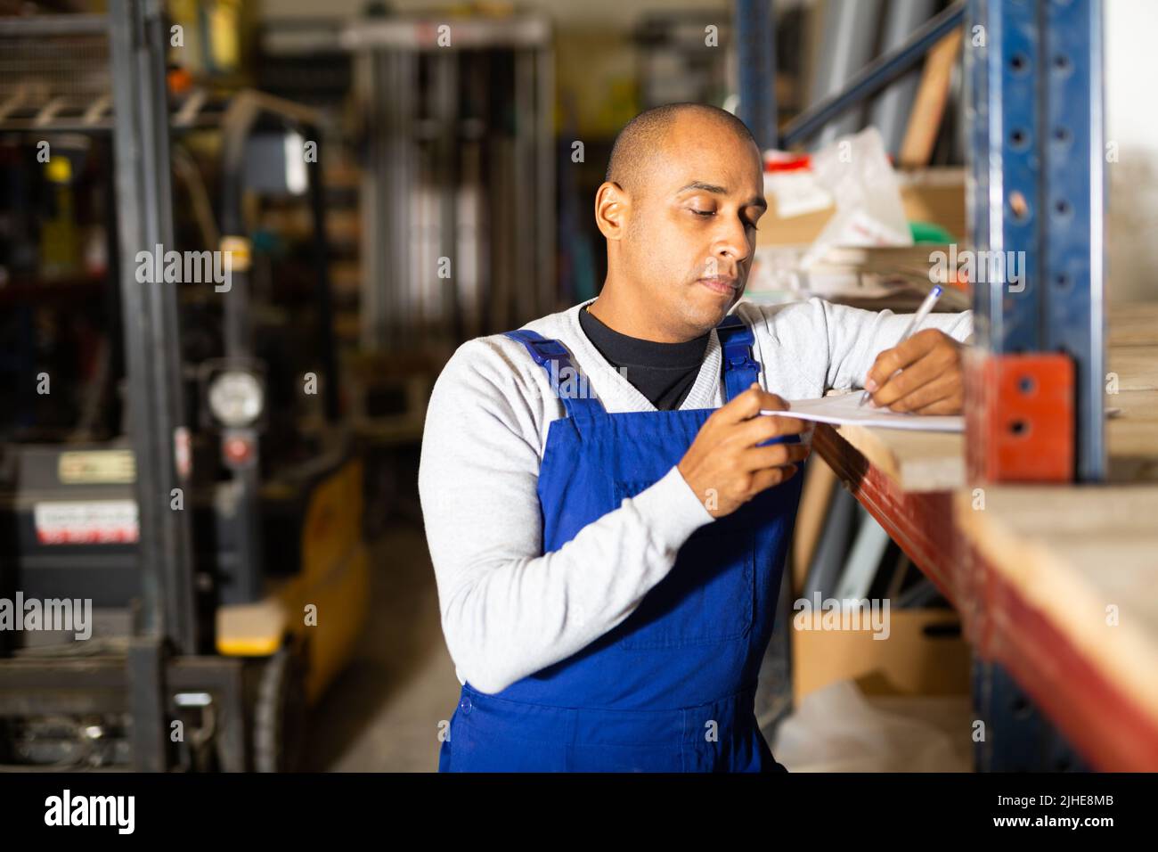 Confident worker taking inventory in building materials store Stock Photo