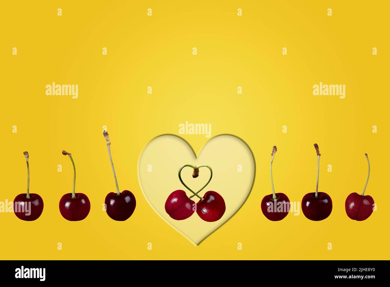 single couple love cherries cherry fruit concept image with row line of cherries & heart on a colorful colourful yellow background Stock Photo