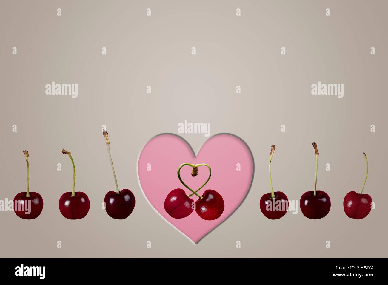 single couple love cherries cherry fruit concept image with row line of cherries & heart on a colorful colourful grey background Stock Photo