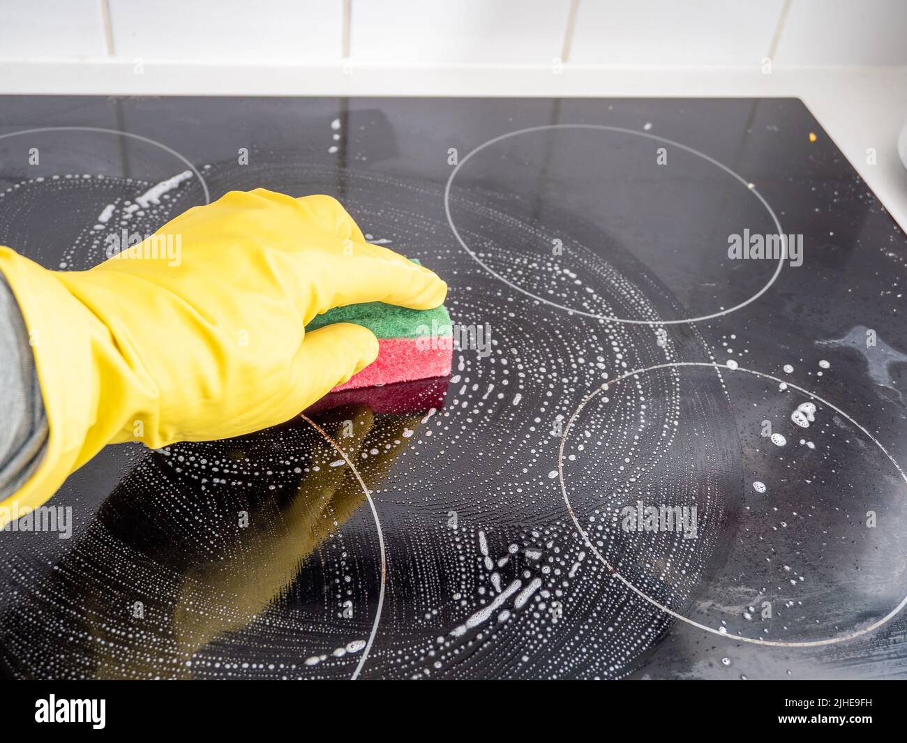 Washes the electric stove. Kitchen cleaning. Dirty electric stove Stock