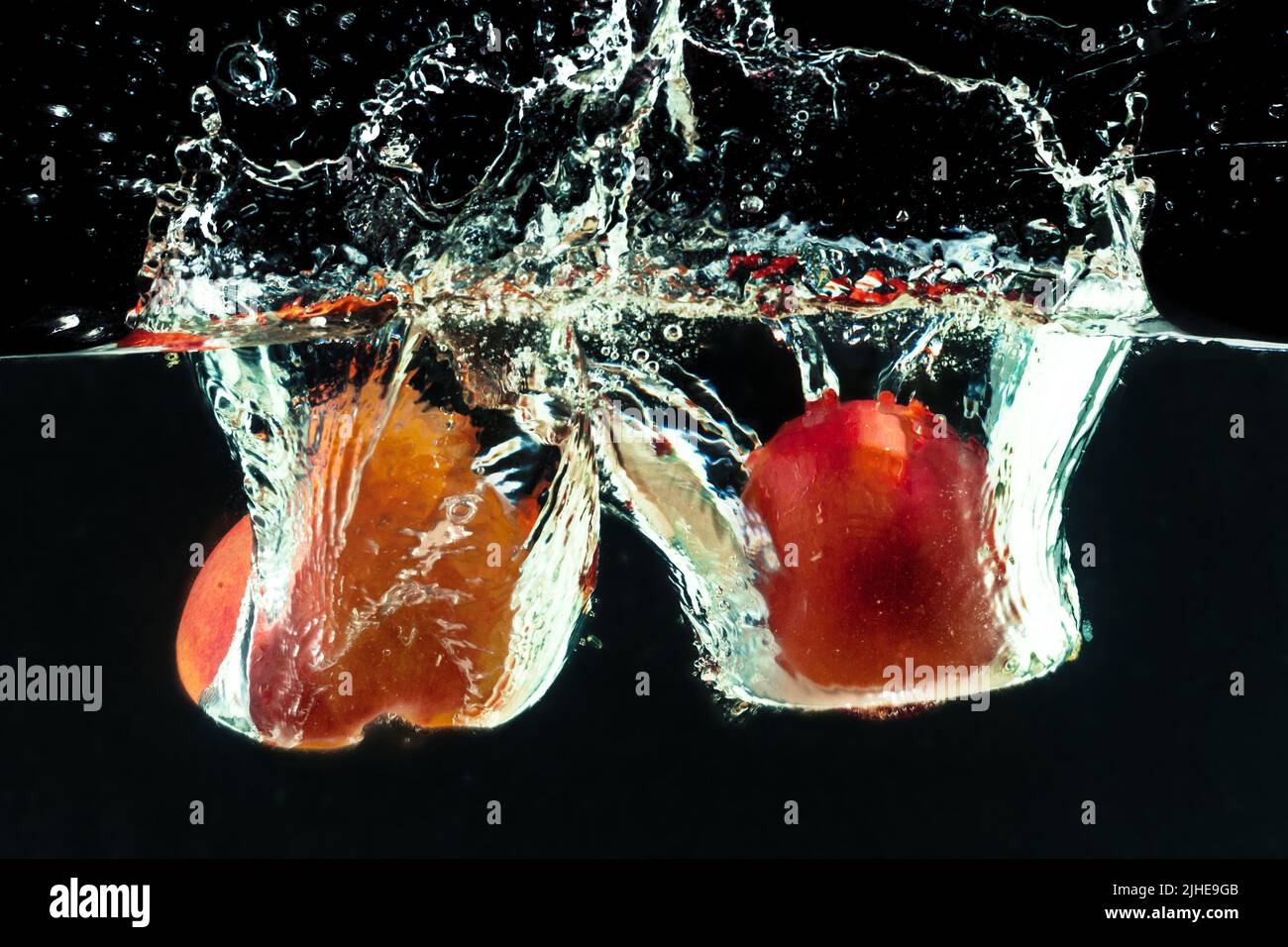 Peach dropped into water with bubbles Stock Photo Alamy