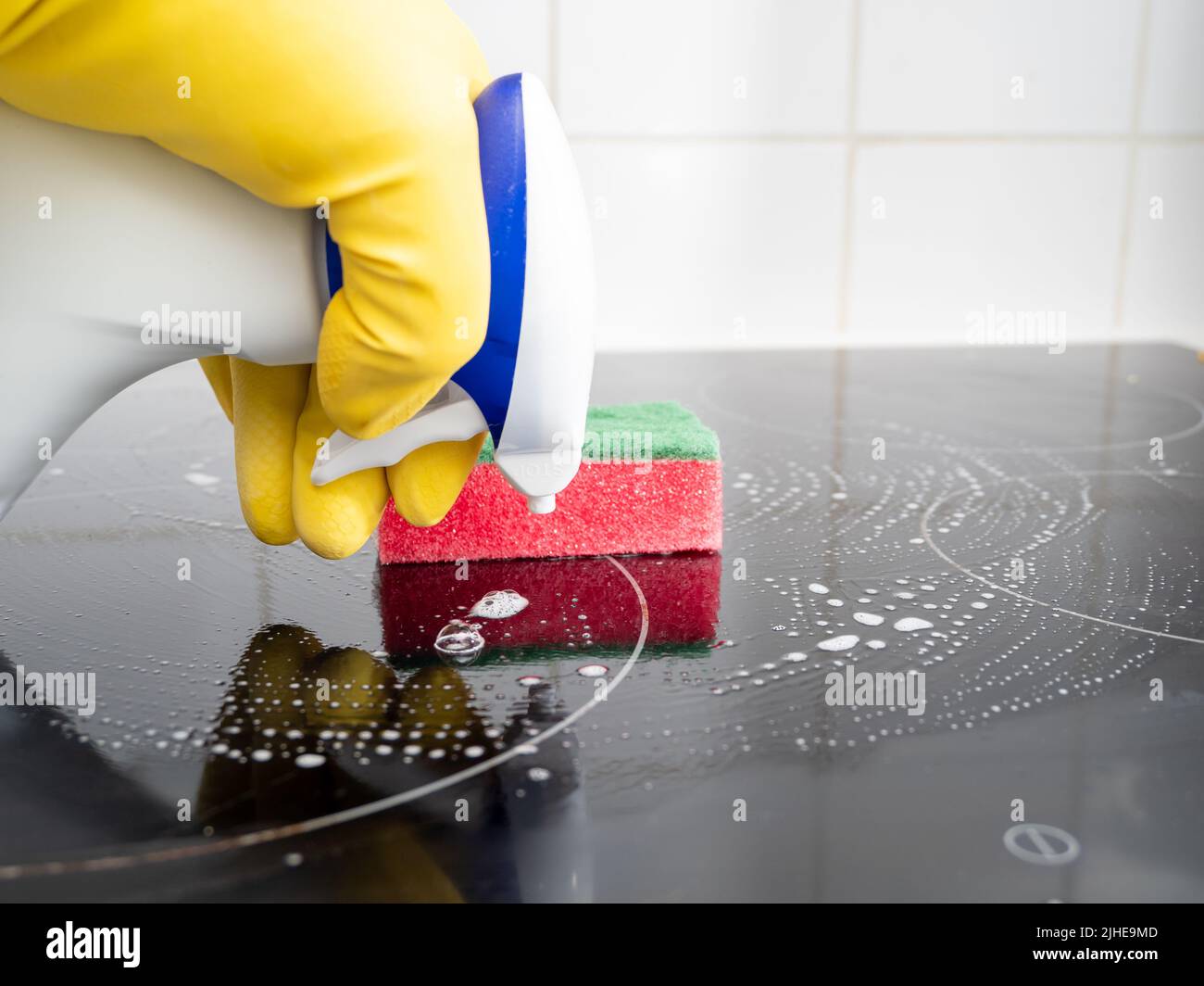 Washes the electric stove. Kitchen cleaning. Dirty electric stove Stock