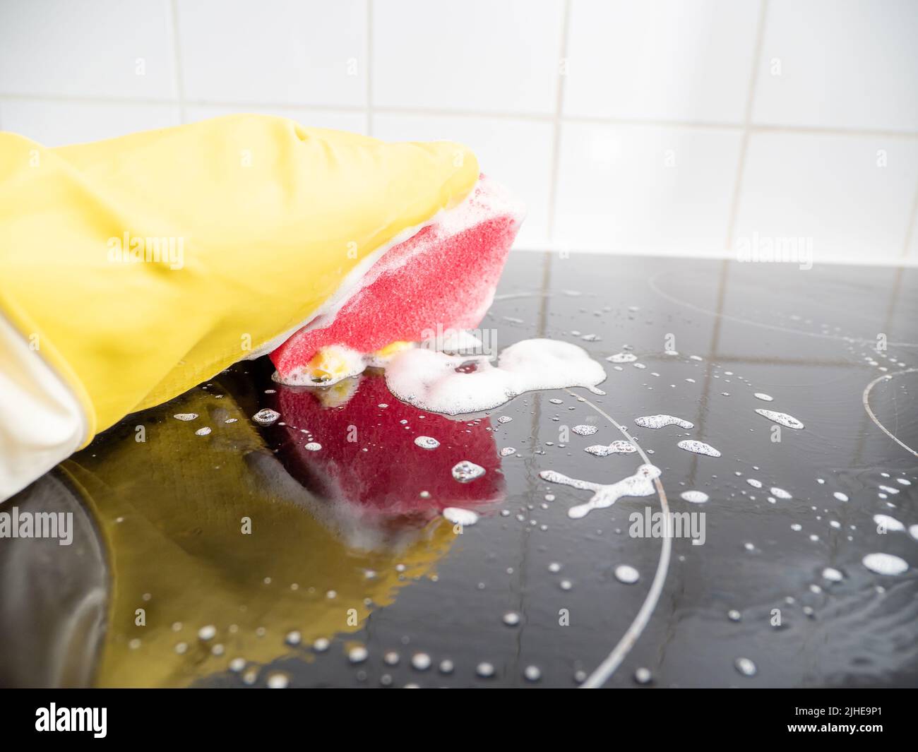 Washes the electric stove. Kitchen cleaning. Dirty electric stove Stock
