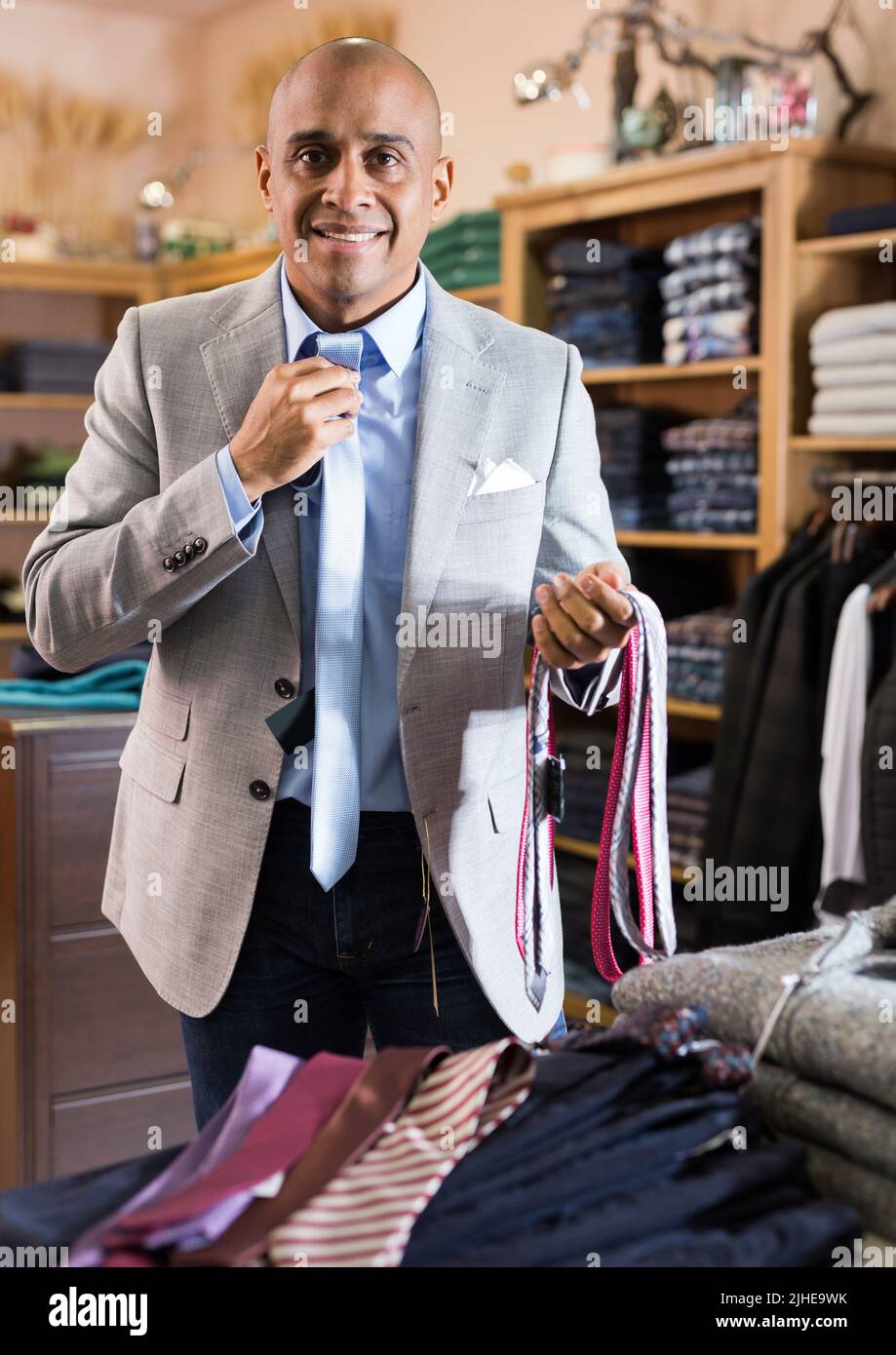 Man choosing new tie in clothing boutique Stock Photo - Alamy