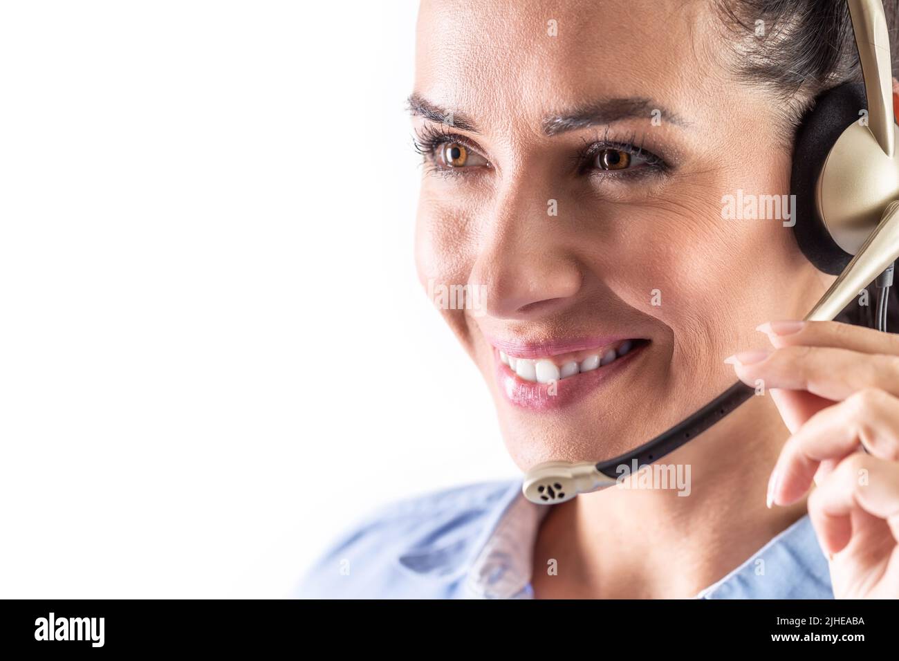Hotline or call center worker smiling as she responds to a call to a customer service center. Stock Photo