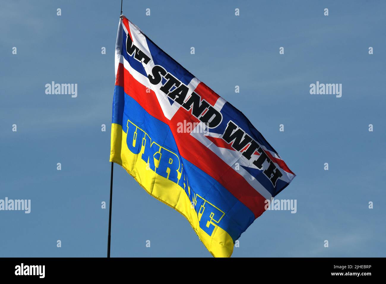 'WE STAND WITH UKRAINE', ON FLAG WITH UK AND UKRAINE INSIGNIA. Stock Photo