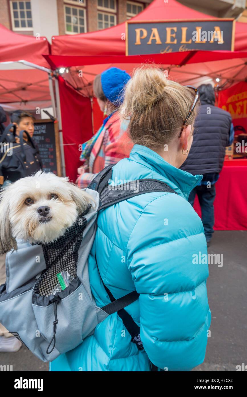 July 16, 2022: With her backpack dog companion, Cindy from the Hills Shire in Sydney considers the Paella at the Christmas in July, Rocks Markets Stock Photo
