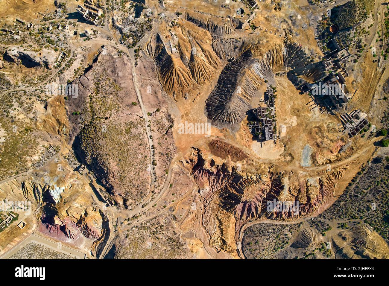 Panoramic aerial shot, drone point of view from above old abandoned mines of Mazarron in Murcia on blue sky background during sunny summer day. Minera Stock Photo