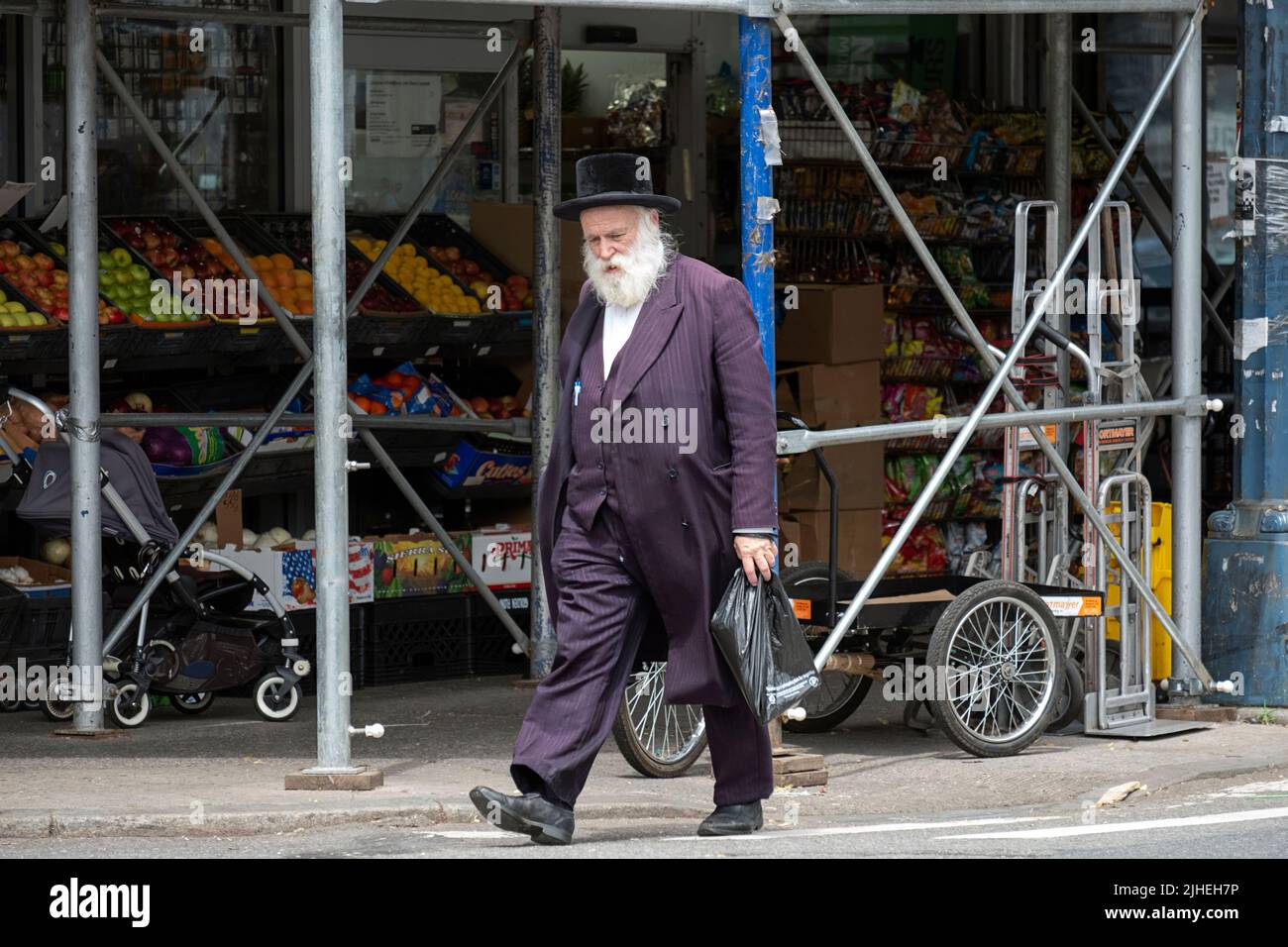 A hasidic Jewish man walks on Lee Avenue after doing some shopping. In Williamsburg, Brooklyn, New York City. Stock Photo