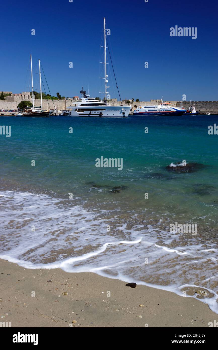 Boats in Rhodes Kolona Harbour with the Old Town Walls in the background, Rhodes, Dodecanese Islands, Greece. Stock Photo
