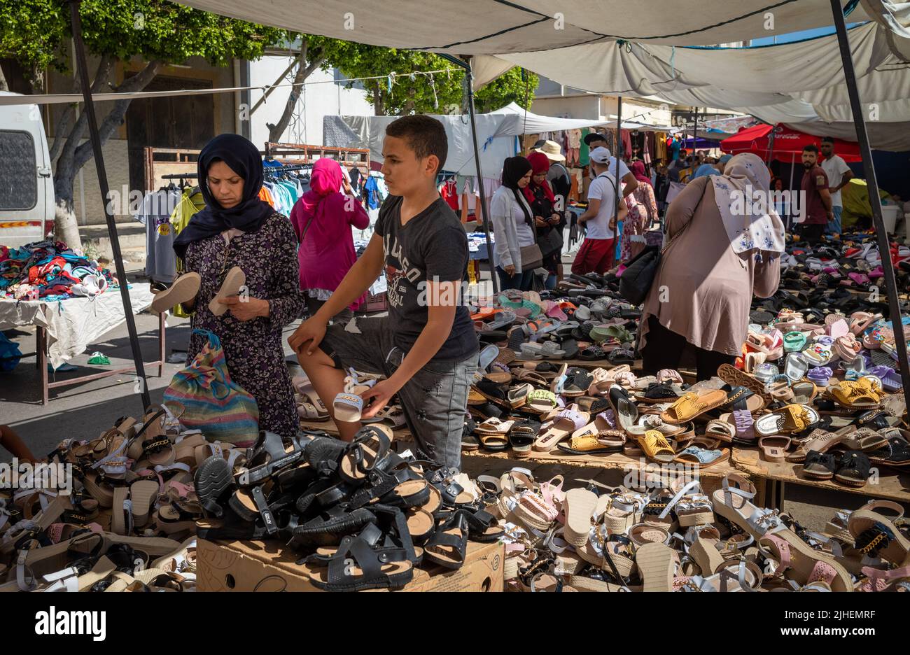 A young man sells women's shoes at the Sunday Souk, a weekly market in Sousse, Tunisia. Stock Photo