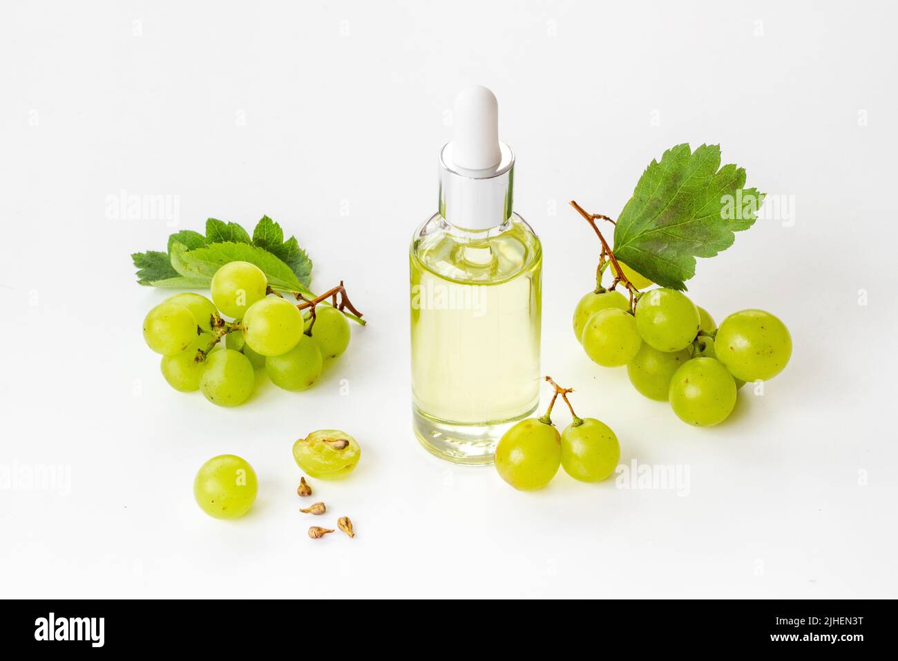 Bottle of grape seed essential oil with grapes. Eco cosmetic product