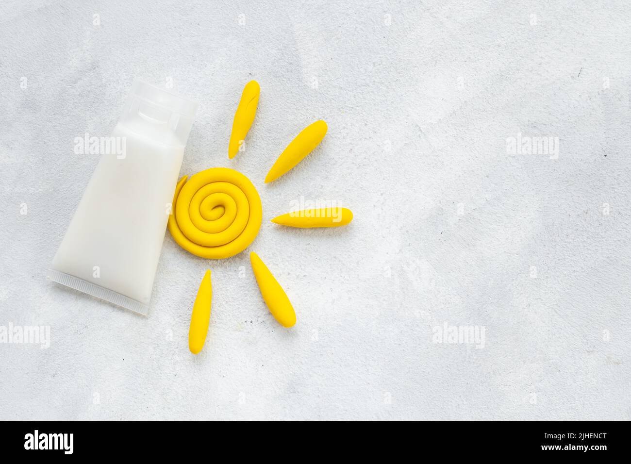 Sun protection lotion and plasticine sun. Summer skin care concept