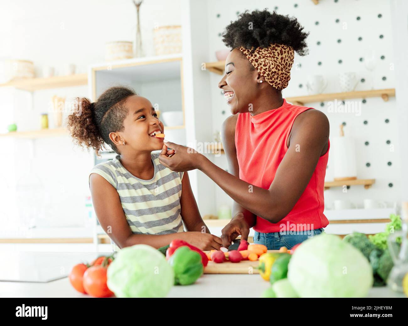 daughter mother kitchen food preparing cooking child bonding happy girl together home parent Stock Photo
