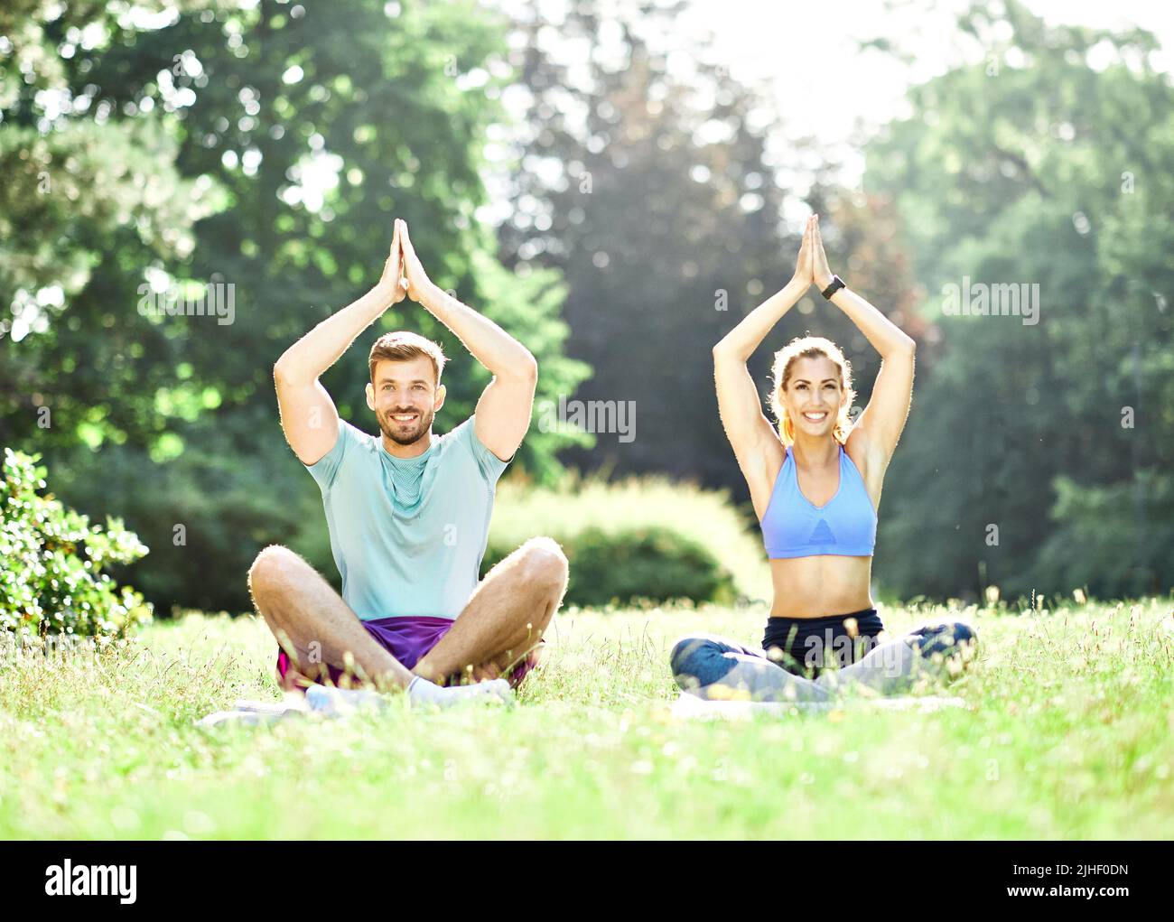 woman man couple yoga park outdoor lifestyle nature healthy fitness sport health exercise relaxation Stock Photo