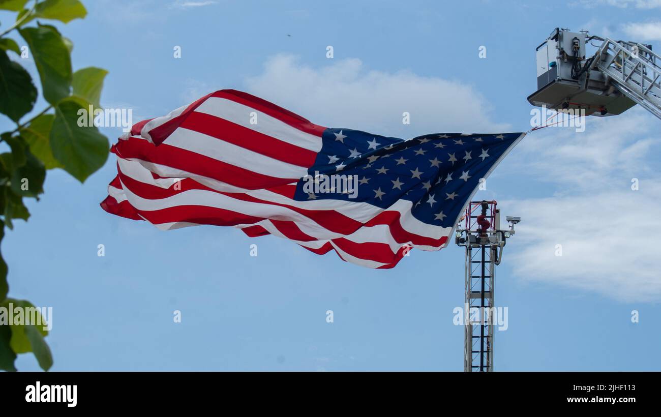 American flag hanging from crane hires stock photography and images